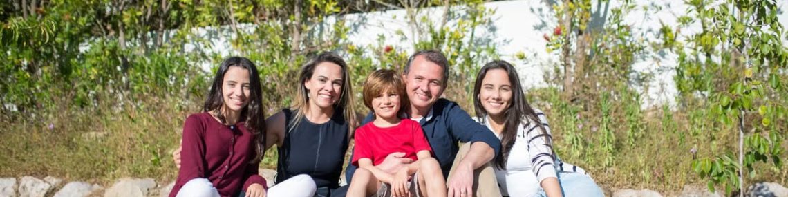 A joyful family enjoying sunny moments in a lush Portuguese garden.